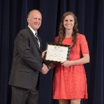 Doctor Potteiger posing for a photo with an award recipient in a coral dress